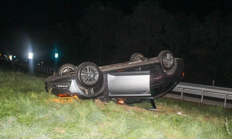 Auf dem Dach liegendes Auto im Gras an der A15 Anschlussstelle Cottbus-West