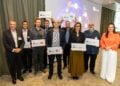 Sieben Partner unter einem Dach: Zum Auftakt der R+I Factory erhielten die beteiligten Einrichtungen und Unternehmen Plaketten als Zeichen ihrer Partnerschaft. Von links nach rechts: Prof. Dr.-Ing. Gerhard Kahmen (IHP); Dr. Pierre-Yves Bourguignon, Leiter Data Science, ENERTRAG; Dr. Martin Handreg, ABB; Dr. Sebastian Meyer, Fraunhofer IPMS; Prof. Dr. Miloš Krstić, Gesamtprojektleiter AI-DISCO, IHP; Mike Reichardt, DFKI; Prof. Dr. Gesine Grande, Präsidentin der BTU Cottbus-Senftenberg; Prof. Dr. Frank W. Ohl, LIN sowie Ministerin Dr. Manja Schüle und Foto: ©IHP GmbH / Frederic Schweizer