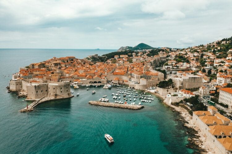 Luftaufnahme der Altstadt von Dubrovnik mit Stadtmauer, Hafen und Booten