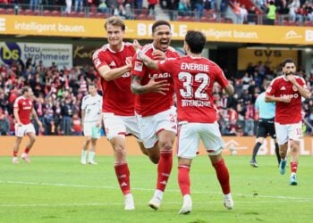 Justin Butler jubelt mit zwei Mitspielern ueber sein Tor zum 1:0