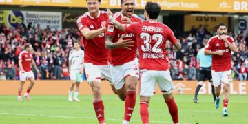 Justin Butler jubelt mit zwei Mitspielern ueber sein Tor zum 1:0