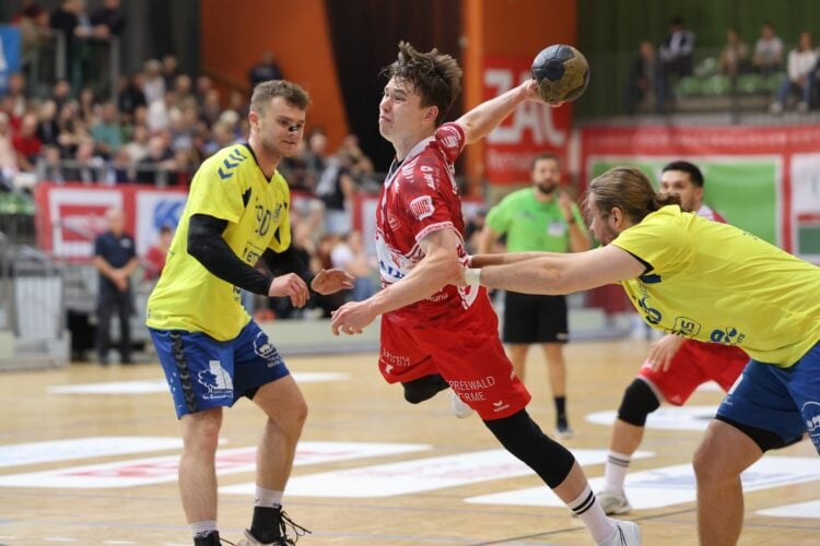 LHC-Spieler Hannes Knecht springt zum Wurf, zwei Luebbenauer versuchen ihn zu stoppen