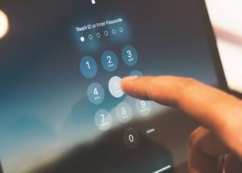 Ein Finger tippt auf einem Tablet-Bildschirm einen Zahlencode zur Entsperrung ein