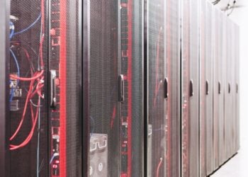Reihe schwarzer Serverschränke in einem Rechenzentrum, davor rote und blaue Netzwerkkabel