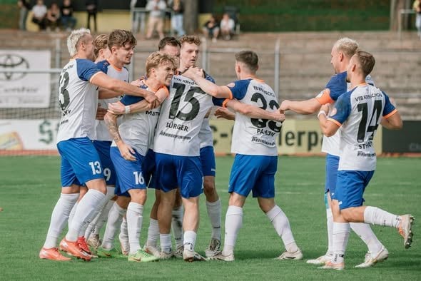 Die Mannschaft des VfB Krieschow feiert einen Treffer in einer Jubeltraube auf dem Rasen