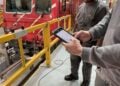 Zwei Techniker mit Tablet vor einem Triebfahrzeug in der Werkstatt