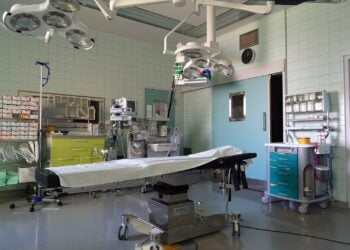 Leerer Operationssaal mit OP-Tisch und Leuchten