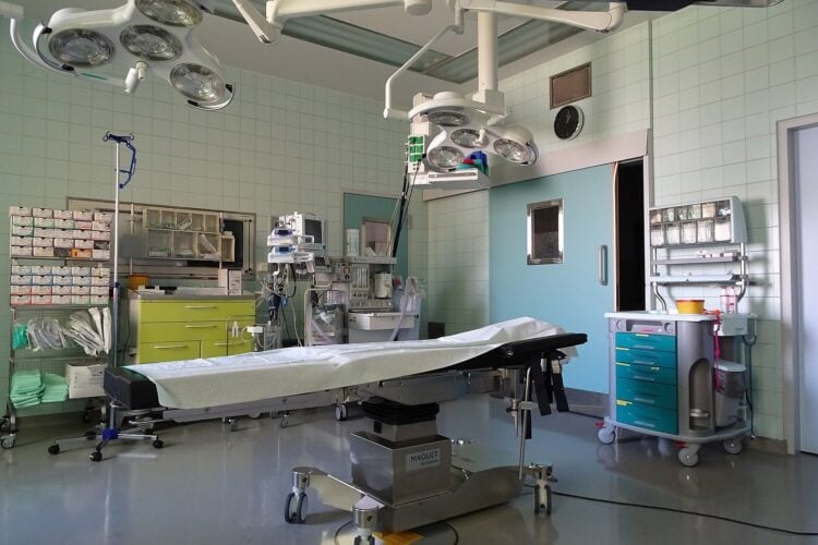 Leerer Operationssaal mit OP-Tisch und Leuchten