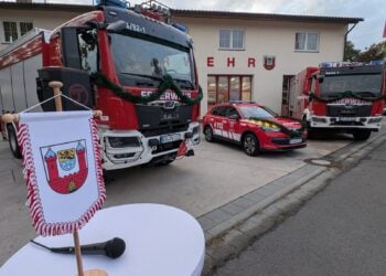 Rüstwagen, Kommandowagen und Löschfahrzeug mit Tannengirlanden vor dem Feuerwehrgerätehaus Calau