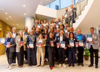 Gruppenfoto der ausgezeichneten Arbeitgeber mit Urkunden und Pokalen auf einer Treppe