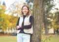 Porträt von Prof. Dr. Cordula Endter, an einen Baum gelehnt im Herbstlaub