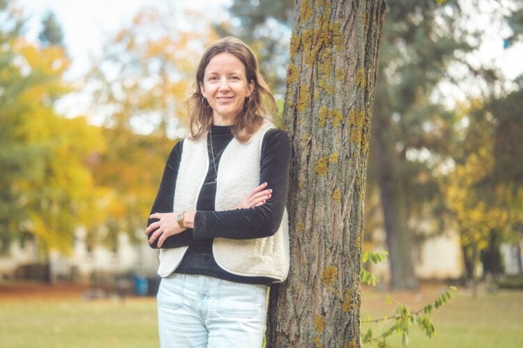 Porträt von Prof. Dr. Cordula Endter, an einen Baum gelehnt im Herbstlaub