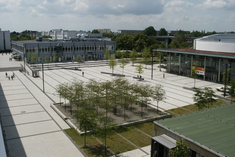 Blick von oben auf den gepflasterten zentralen Platz des BTU-Campus mit Baumreihen und Gebäuden