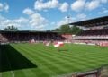 Blick in das Stadion der Freundschaft in Cottbus mit gefüllten Rängen und Fahnenschwenkern auf dem Rasen