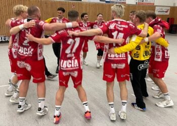 Die Handballer des LHC Cottbus stehen nach dem Sieg in Altlandsberg Arm in Arm im Kreis in der Halle