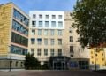 Bürogebäude Am Turm 14 in Cottbus mit Glaseingang, daneben ein Baum