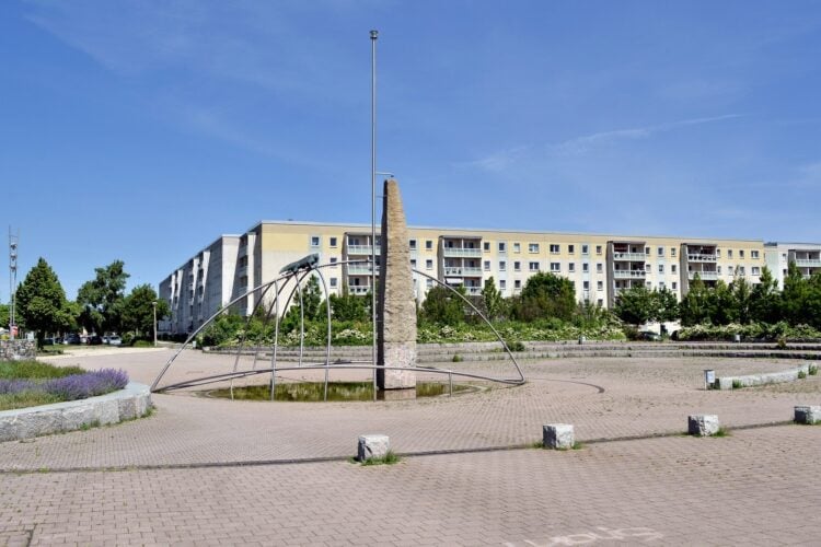 Brunnen auf dem Ernst-Mucke-Platz in Cottbus-Schmellwitz mit Plattenbauten im Hintergrund