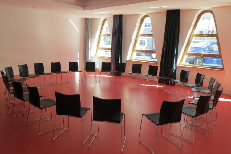 Stühle stehen im Kreis in einem hellen Raum