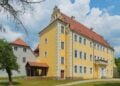 Das Schloss in Lübben mit Turm unter blauem Himmel