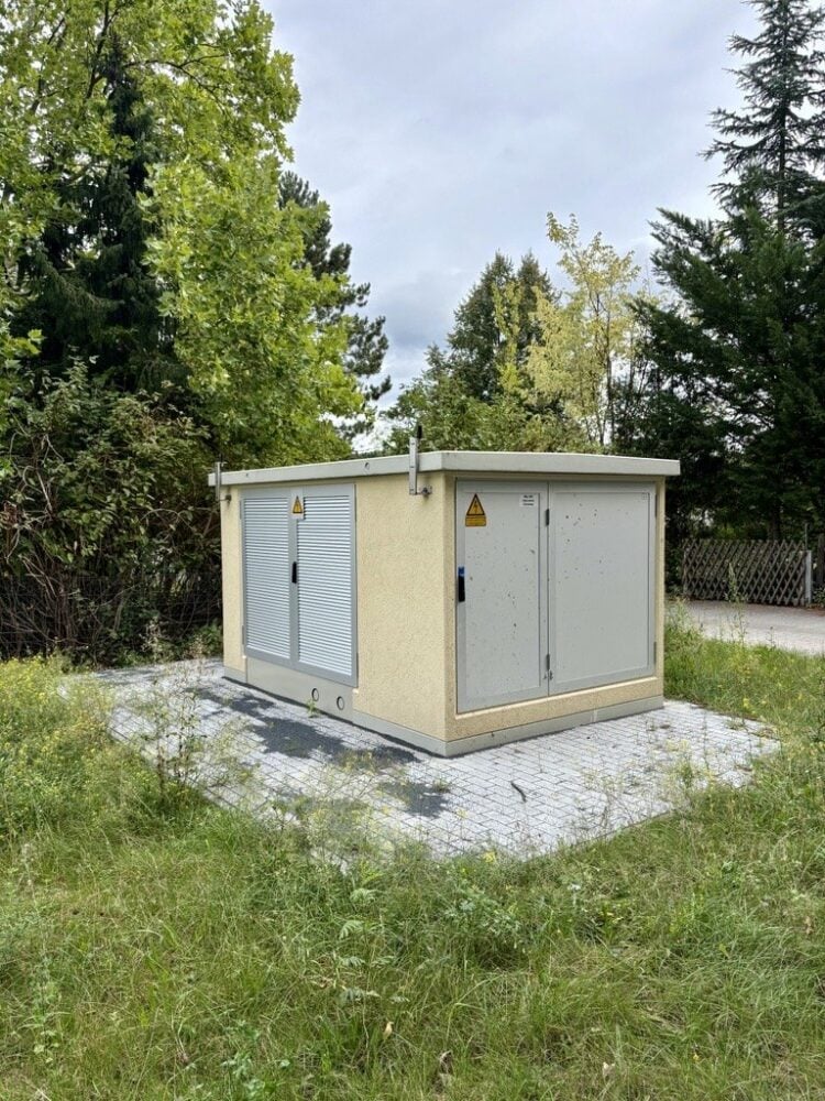 Ortsnetztrafostation mit grauen Türen und Lüftungsgittern auf einer gepflasterten Fläche am Eichenweg in Elsterwerda