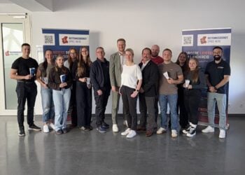Gruppenfoto von 15 Personen in einem hellen Raum vor zwei Aufstellern des Rettungsdienstes Spree-Neiße