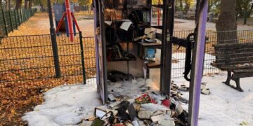 Die ausgebrannte Bücherzelle am Spielplatz in Alt Großziethen mit verkohlten Büchern davor