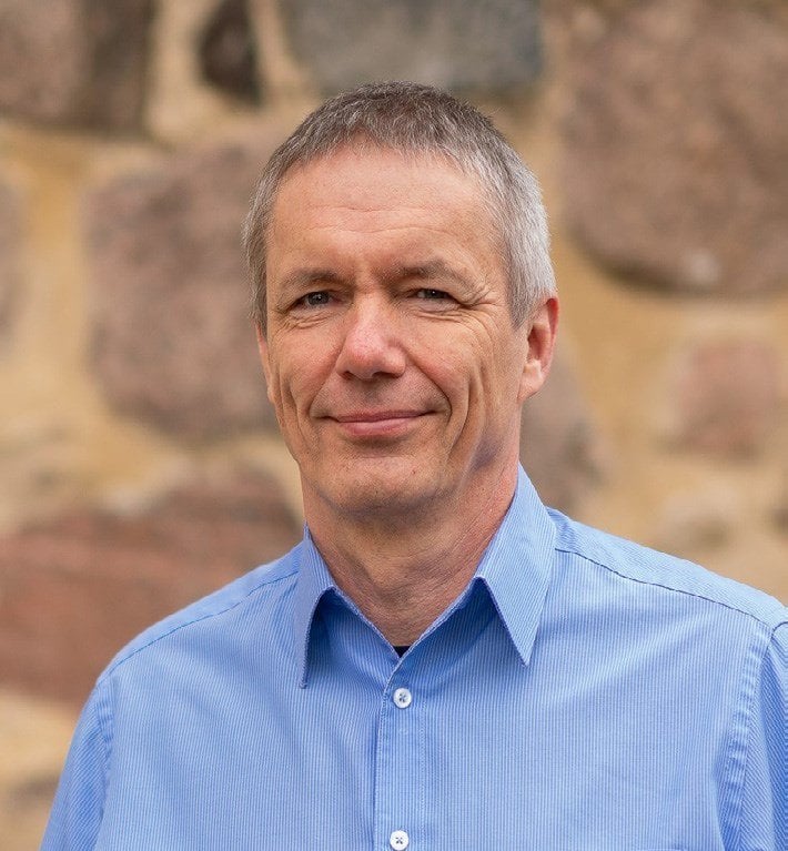 Porträt von Landeskonservator Prof. Dr. Thomas Drachenberg vor einer Feldsteinmauer