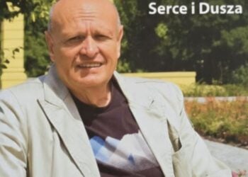 Roland Hellmann sitzt im hellen Sakko auf einer Bank in einem Park