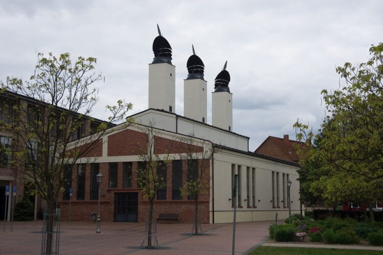Backsteinbau mit drei weißen Türmen und dunklen Hauben auf dem Gelände der ehemaligen Hutfabrik Wilke in Guben