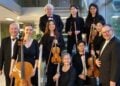 Musikerinnen und Musiker des Brandenburgischen Konzertorchesters Eberswalde mit Cello, Violinen, Flöte und Klarinette auf einer Treppe