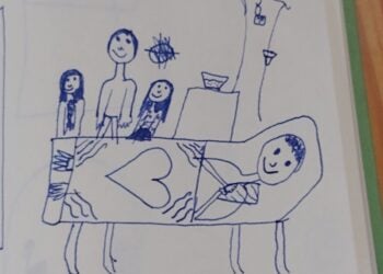 Kinderzeichnung mit Stift: Eine Familie steht an einem Krankenbett, auf der Bettdecke ist ein großes Herz gemalt