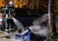 Feuerwehrmann löscht die Reste einer ausgebrannten Tonne in Königs Wusterhausen