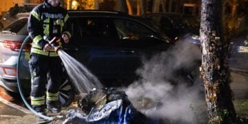 Feuerwehrmann löscht die Reste einer ausgebrannten Tonne in Königs Wusterhausen