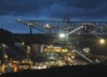 Beleuchtete Förderbrücke und Großgeräte im Tagebau Welzow-Süd in der Abenddämmerung