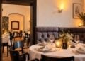 KI-bearbeitetes Bild eines gedeckten Restaurant-Gastraums mit Kerzen, Weingläsern und Polsterbank