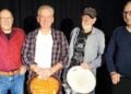 Vier Musiker der Band Bright Madness mit Gitarre und Trommel vor dunklem Hintergrund