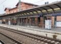 Bahnsteig und Gleise am Bahnhof Lübbenau (Spreewald), dahinter das Empfangsgebäude aus Backstein