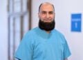 Chefarzt Dr. Ahmad Oyais in hellblauer OP-Kleidung auf einem Klinikflur