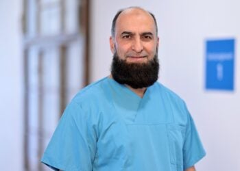 Chefarzt Dr. Ahmad Oyais in hellblauer OP-Kleidung auf einem Klinikflur