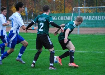 Spieler der BSG Chemie Schwarzheide in Grün und des FSV Guteborn in Blau-Weiß im Zweikampf um den Ball