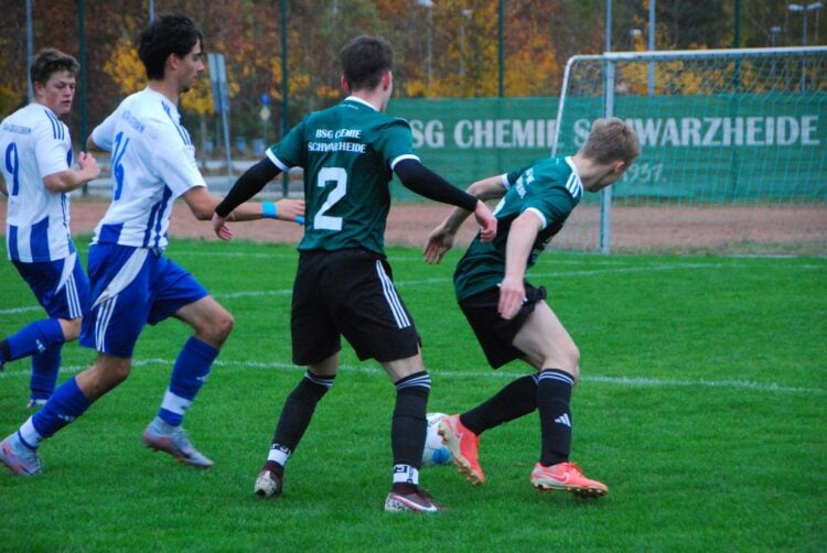 Spieler der BSG Chemie Schwarzheide in Grün und des FSV Guteborn in Blau-Weiß im Zweikampf um den Ball