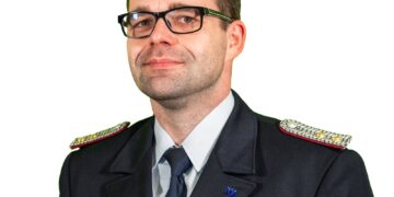 Robert Buder in Feuerwehr-Dienstuniform mit Brille vor weißem Hintergrund