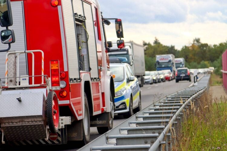 Feuerwehrfahrzeug und Streifenwagen auf der B97 bei Spremberg, dahinter stauen sich Autos und Lastwagen