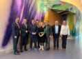 Die Delegation der Lausitzrunde mit Bundesumweltminister Carsten Schneider vor einer bunten Wandmalerei im Ministerium in Berlin