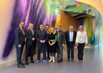 Die Delegation der Lausitzrunde mit Bundesumweltminister Carsten Schneider vor einer bunten Wandmalerei im Ministerium in Berlin