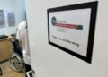 Tür des Pflegestützpunktes Oberspreewald-Lausitz mit Schild Pflege- und Sozialberatung, dahinter ein Beratungsraum mit Rollstuhl