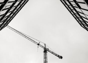 Baukran zwischen zwei Wohnhäusern, Schwarz-Weiß-Aufnahme