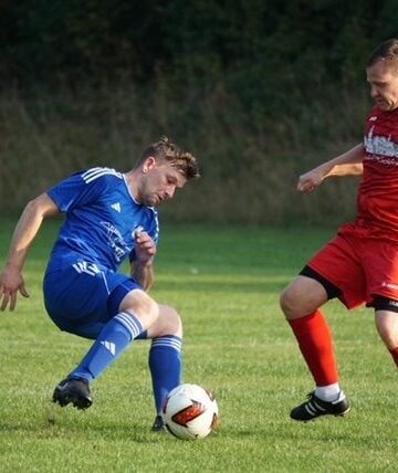 Ein Lichterfelder Spieler in Blau und ein Kostebrauer Spieler in Rot im Zweikampf