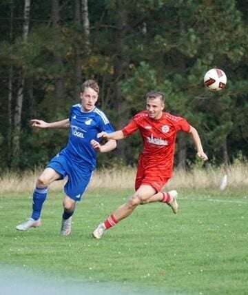 Zwei Spieler laufen einem hohen Ball nach