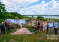 Wortwechsel in Altdöbern: Menschen halten in einer Landschaft am See ein großes Bildbanner